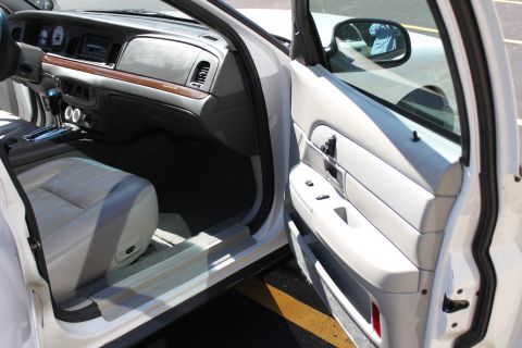 2003 Ford Crown Victoria - Interior view of a white 2003 Ford Crown Victoria, highlighting the dashboard and front door panel.
