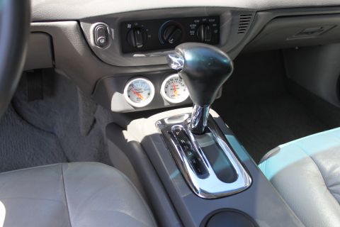 2003 Ford Crown Victoria - Close-up of the center console showing aftermarket gauges and the gear selector.