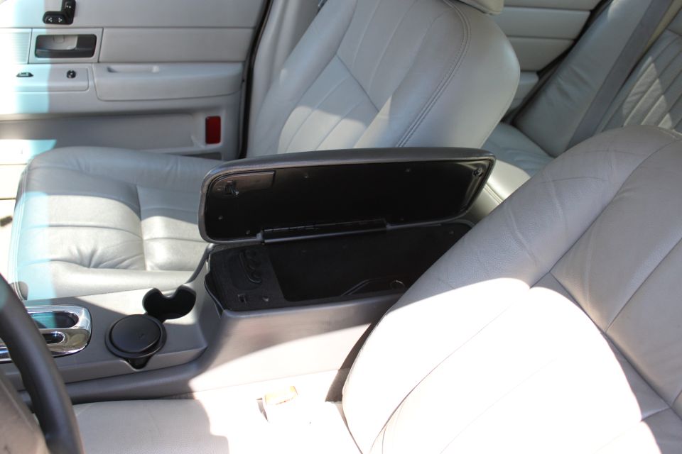 2003 Ford Crown Victoria interior showing front seats, center console with open armrest, and part of the steering wheel