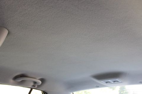 2003 Ford Crown Victoria - The interior ceiling of a car shows a grab handle and a light fixture, with a website watermark.