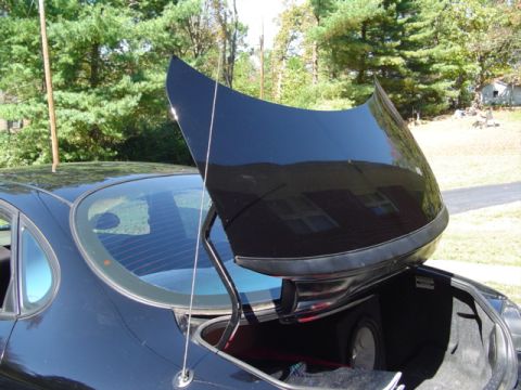 1999 Ford Taurus - Rear three-quarter view of a black sedan with the trunk lid raised, showing a mast antenna on the rear quarter and a subwoofer enclosure wi…