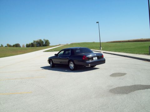 1999 Mercury Grand Marquis - Rear view of a Mercury Grand Marquis sedan parked outdoors on a sunny day.