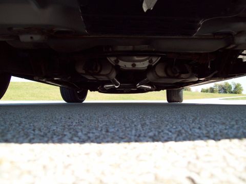 1999 Mercury Grand Marquis - Underside view of a car's drivetrain and exhaust system, including mufflers and tailpipes.