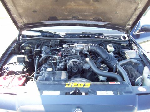 1999 Mercury Grand Marquis - The engine bay of a vehicle is shown with the hood open, revealing the motor and JEGS branding.