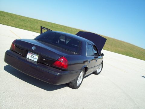 1999 Mercury Grand Marquis - This sedan has tinted windows and a license plate that reads 'MGM 6P'.