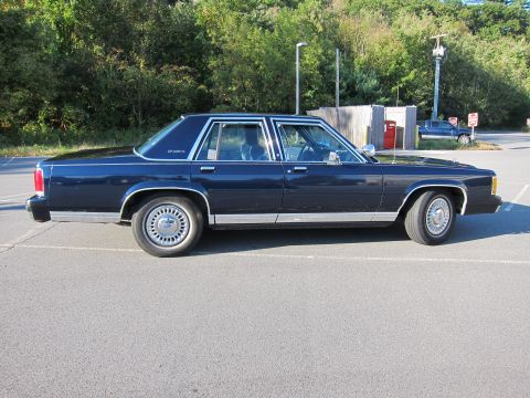 1991 Ford LTD Crown Victoria - Side profile of a 1991 Ford Crown Victoria LTD sedan parked outdoors on asphalt.
