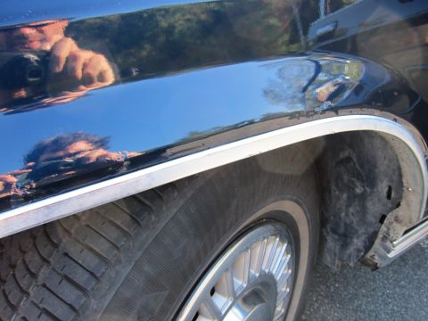 1991 Ford LTD Crown Victoria - Close-up of the side of a 1991 Ford Crown Victoria LTD, focusing on the fender and wheel area.