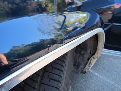 1991 Ford LTD Crown Victoria - Close-up of the fender on a 1991 Ford Crown Victoria LTD, showing chrome trim and signs of rust.