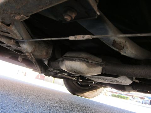 1991 Ford LTD Crown Victoria - Close-up of the undercarriage, focusing on the exhaust system and suspension components.