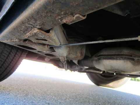 1991 Ford LTD Crown Victoria - The undercarriage of a vehicle displays significant rust on its frame and suspension components.