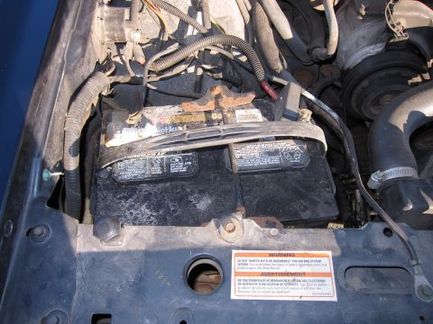 1991 Ford LTD Crown Victoria - Close-up view of a car's engine bay, focusing on the battery and surrounding components.