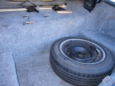 1991 Ford LTD Crown Victoria - The interior of a car trunk shows a spare tire and jack, consistent with a 1991 Ford Crown Victoria LTD.
