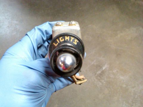 1954 Ford Customline - A vintage light switch with the word "LIGHTS" visible is held by a gloved hand.