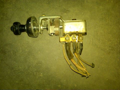 1954 Ford Customline - A vintage headlight switch assembly, a black knob and multiple electrical wires, lies on a textured surface.