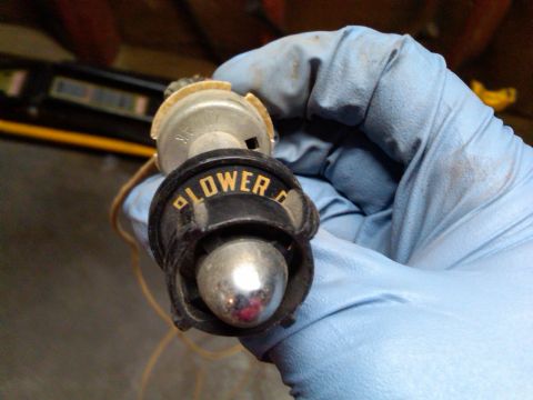 1954 Ford Customline - A gloved hand holds a vintage blower motor switch, showing the 'LOWER' and 'OFF' settings.