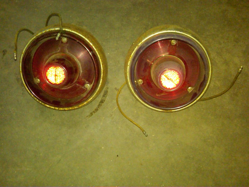 Pair of round red taillights with chrome bezels and wiring