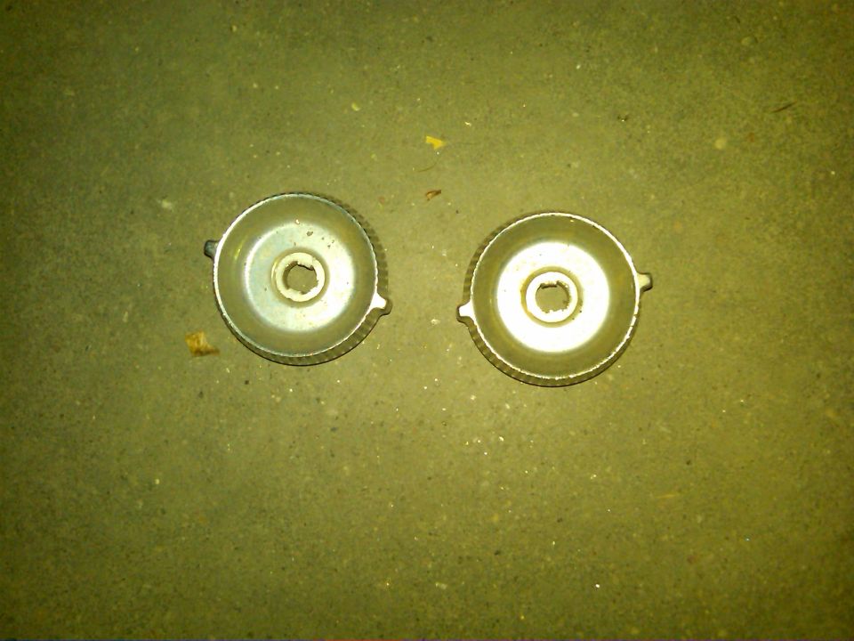 Two metal caps with knurled edges and central hexagonal openings