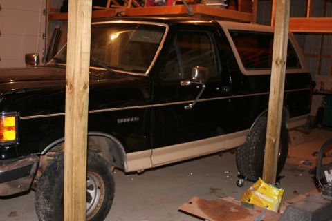 1989 Ford Bronco - This 1989 Ford Bronco is seen in a garage with wooden beams in the foreground.