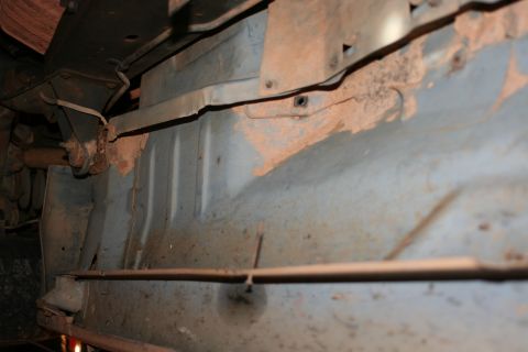 1989 Ford Bronco - Underside view of a vehicle's frame and suspension, showing signs of rust and dirt accumulation.