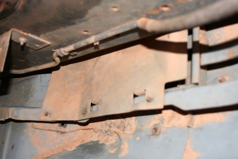 1989 Ford Bronco - Undercarriage view of a metal bracket and fuel line, showing signs of rust.