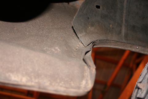 1989 Ford Bronco - A torn section of the inner fender liner is visible, showing wear and tear.