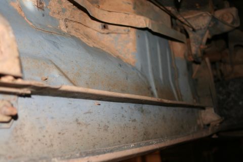 1989 Ford Bronco - The undercarriage of a vehicle displays significant rust and wear on its structural components.