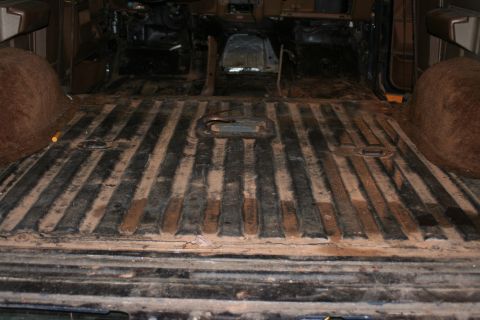 1989 Ford Bronco - The interior of a vehicle shows a ribbed floor and exposed metal components, suggesting it is undergoing restoration or repair.