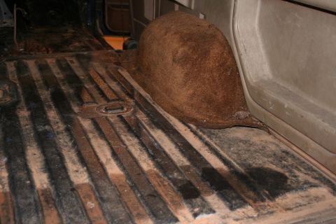 1989 Ford Bronco - The interior floor and rear wheel well of a vehicle are visible in this image.