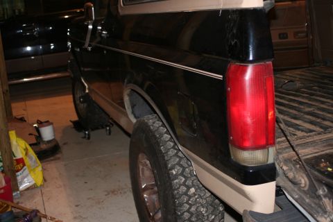 1989 Ford Bronco - The rear section of a two-tone Ford Bronco is visible, parked indoors with another vehicle nearby.