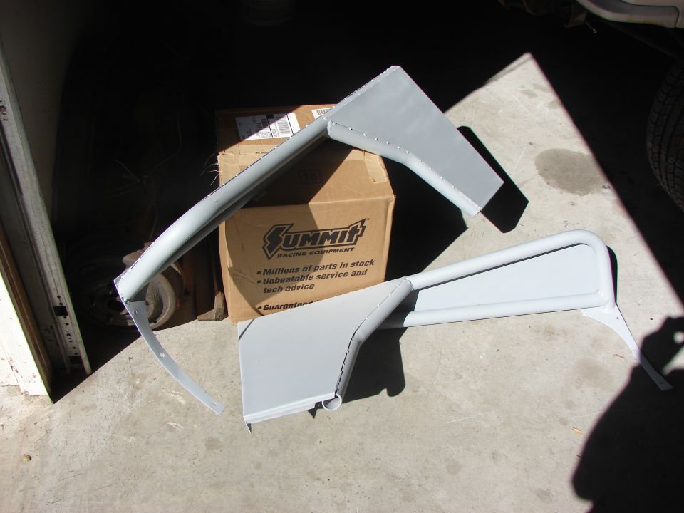 Two gray metal fender flare parts in front of Summit Racing box