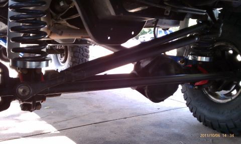 1994 Ford Bronco - The undercarriage of a vehicle shows a lifted suspension system with prominent coil springs and differential components.