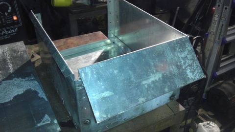 1989 Ford Bronco - A metal box with a hinged flap is shown in a workshop setting.