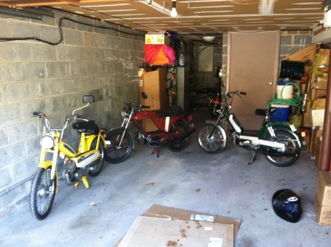1981 Garelli Rally Sport - Three mopeds are parked inside a garage, with various items stored around them.