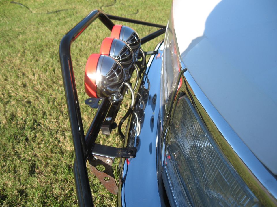 Front view of a vehicle with a Pro Runner light bar and three chrome and red lights