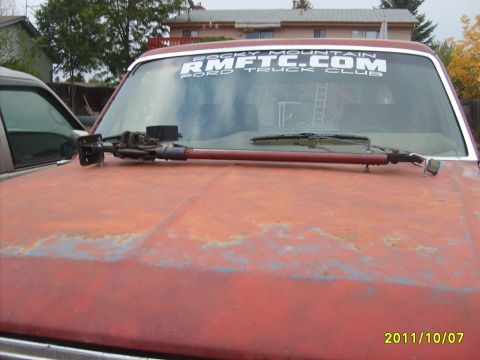 1986 Ford Bronco - A red truck with a HiLift jack on the hood and a Ford Truck Club banner on the windshield.