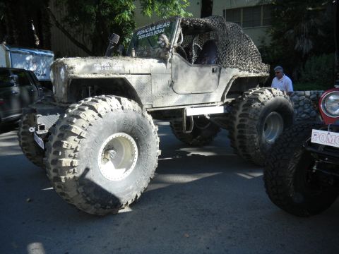 1997 Ford Ranger - This heavily modified Jeep CJ features oversized tires and camouflage netting, with contact information visible on the door.