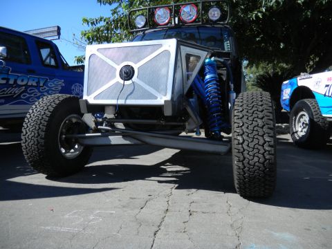 1997 Ford Ranger - A custom-built off-road vehicle is shown from the front, prominent blue suspension components and large tires, with other vehicles visible…