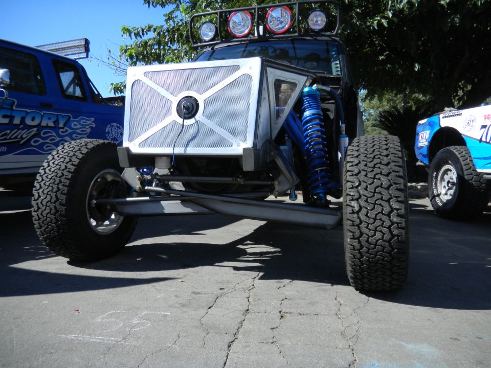 Custom off-road vehicle front view with blue suspension and large tires