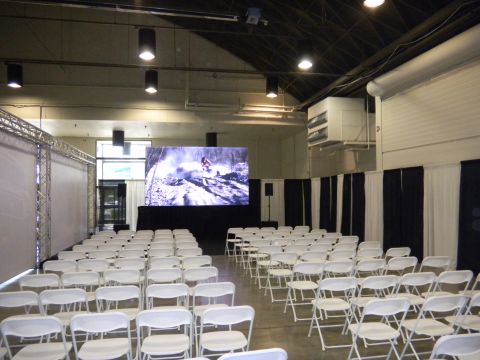 1997 Ford Ranger - An indoor venue is set up with seating and a large display screen showing an action sports scene.