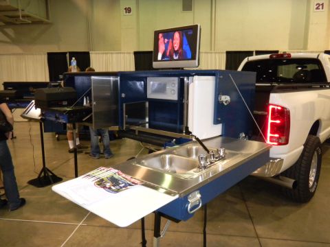 1997 Ford Ranger - A white pickup truck is equipped with a custom slide-out unit a sink, microwave, and television.
