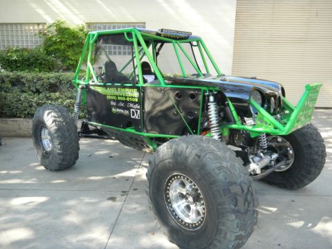 1997 Ford Ranger - This custom buggy features a prominent green roll cage and oversized tires, suggesting it's built for extreme off-road use.