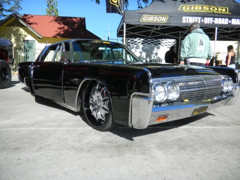 1997 Ford Ranger - A customized black 1963 Lincoln Continental is displayed at an outdoor event with a Gibson tent in the background.