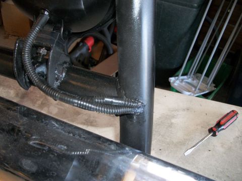 1996 Ford Bronco - Close-up of vehicle frame components and wiring, with a screwdriver nearby.