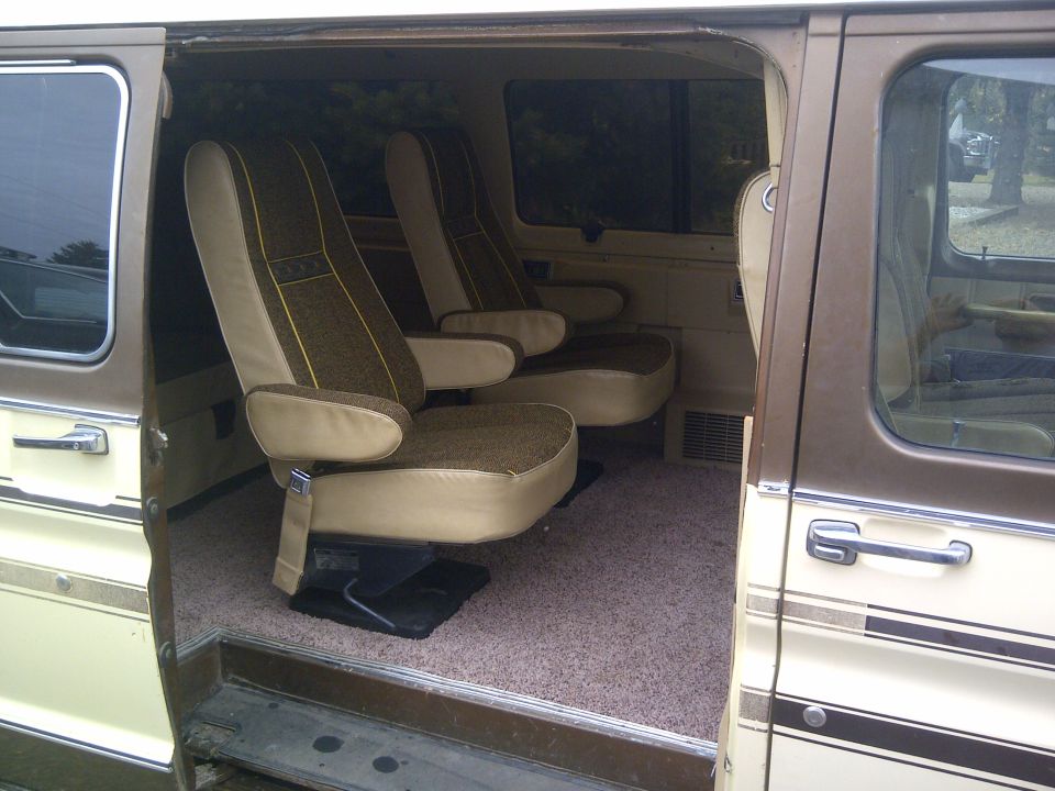 Interior of a 1979 Ford E250 van showing two rows of captain's chairs with brown and tan upholstery