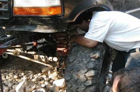 1993 Ford Bronco - A person inspects the suspension system of a modified off-road vehicle.