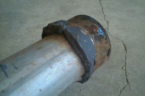 1987 Ford Bronco - Close-up view of a rusted exhaust pipe flange.