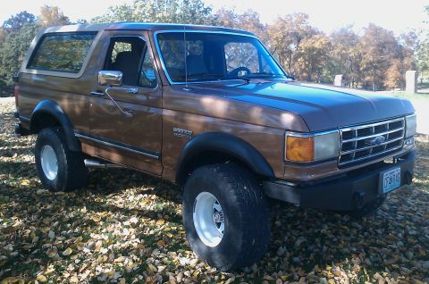 1987 Ford Bronco - This 1987 Ford Bronco features a two-tone brown paint job and is equipped with aftermarket wheels and tires.