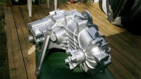 1995 Ford F-150 - A silver transfer case is shown outdoors on a wooden deck.