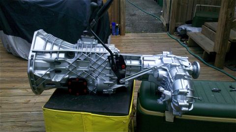 1995 Ford F-150 - A silver transmission and transfer case assembly is displayed on a stand outdoors.