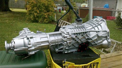 1995 Ford F-150 - ZF5 transmission and transfer case assembly, painted silver, outdoors.